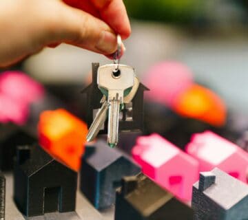 House keys held above model homes representing buy to let mortgage advice